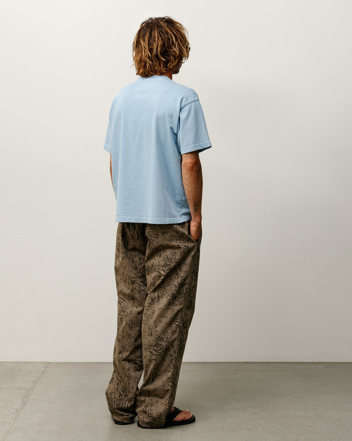Garment Dyed SS Tee T-Shirt in Dust Blue, back view; relaxed-fit cotton crewneck short sleeve, Stüssy patch at neck.