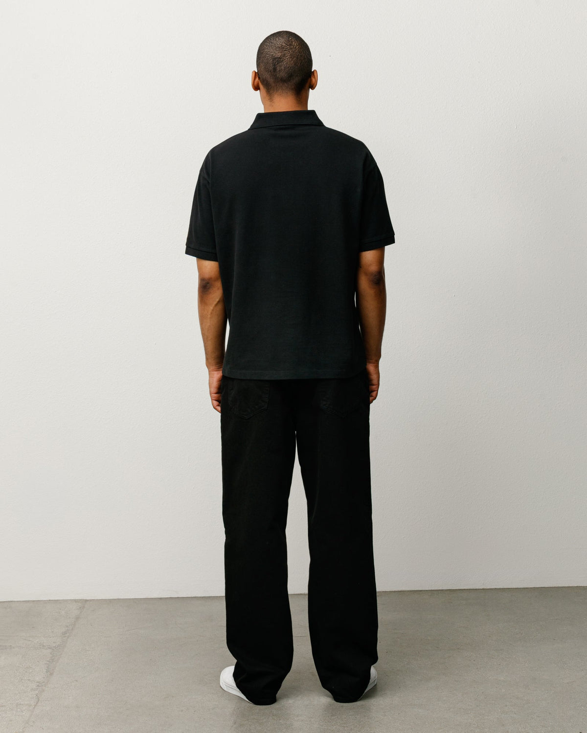 Classic Pique Polo in Black, on-model back view in midweight cotton pique with rib knit collar.