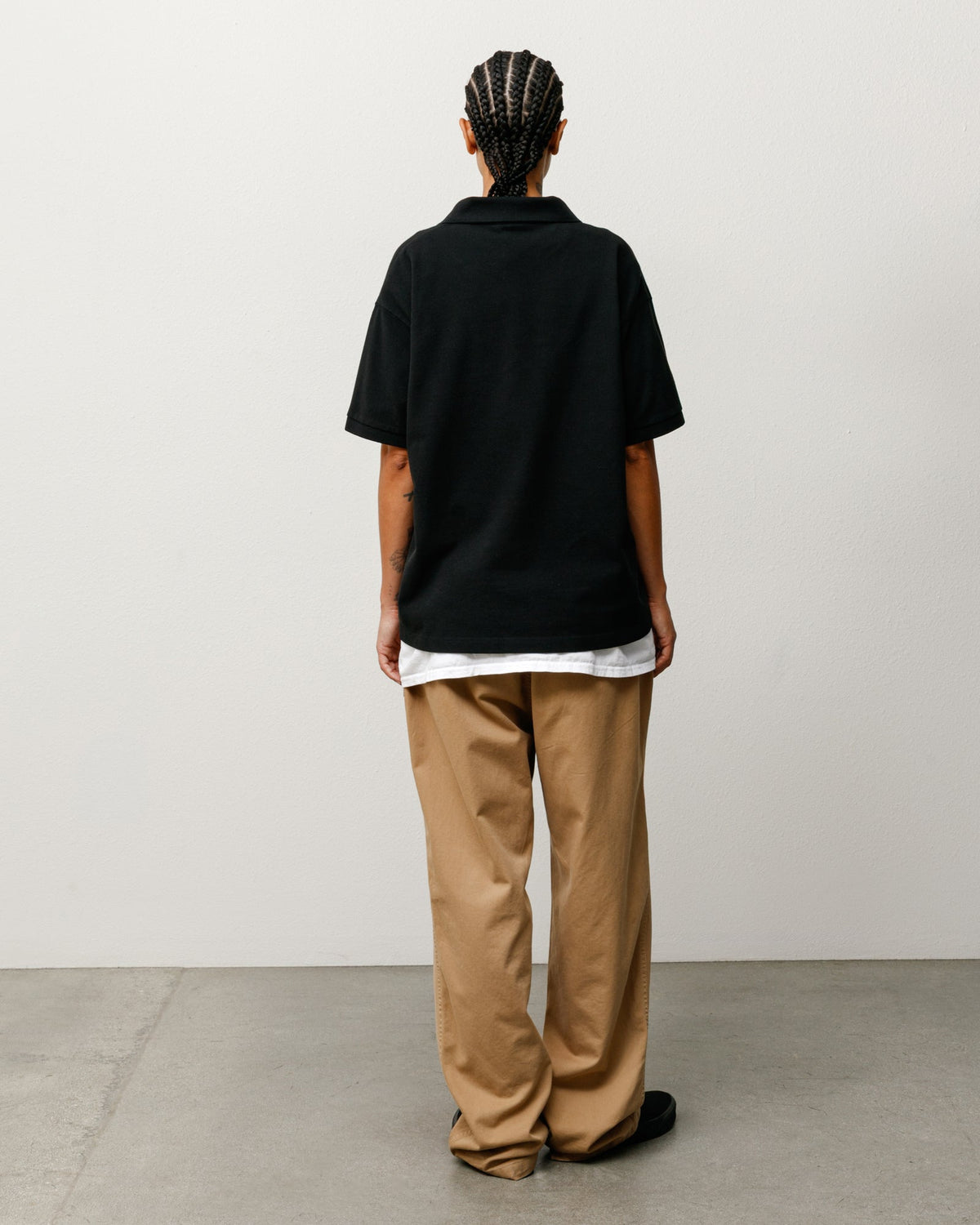 Stüssy Classic Pique Polo in Black, back view; midweight cotton pique with rib collar and cuffs.