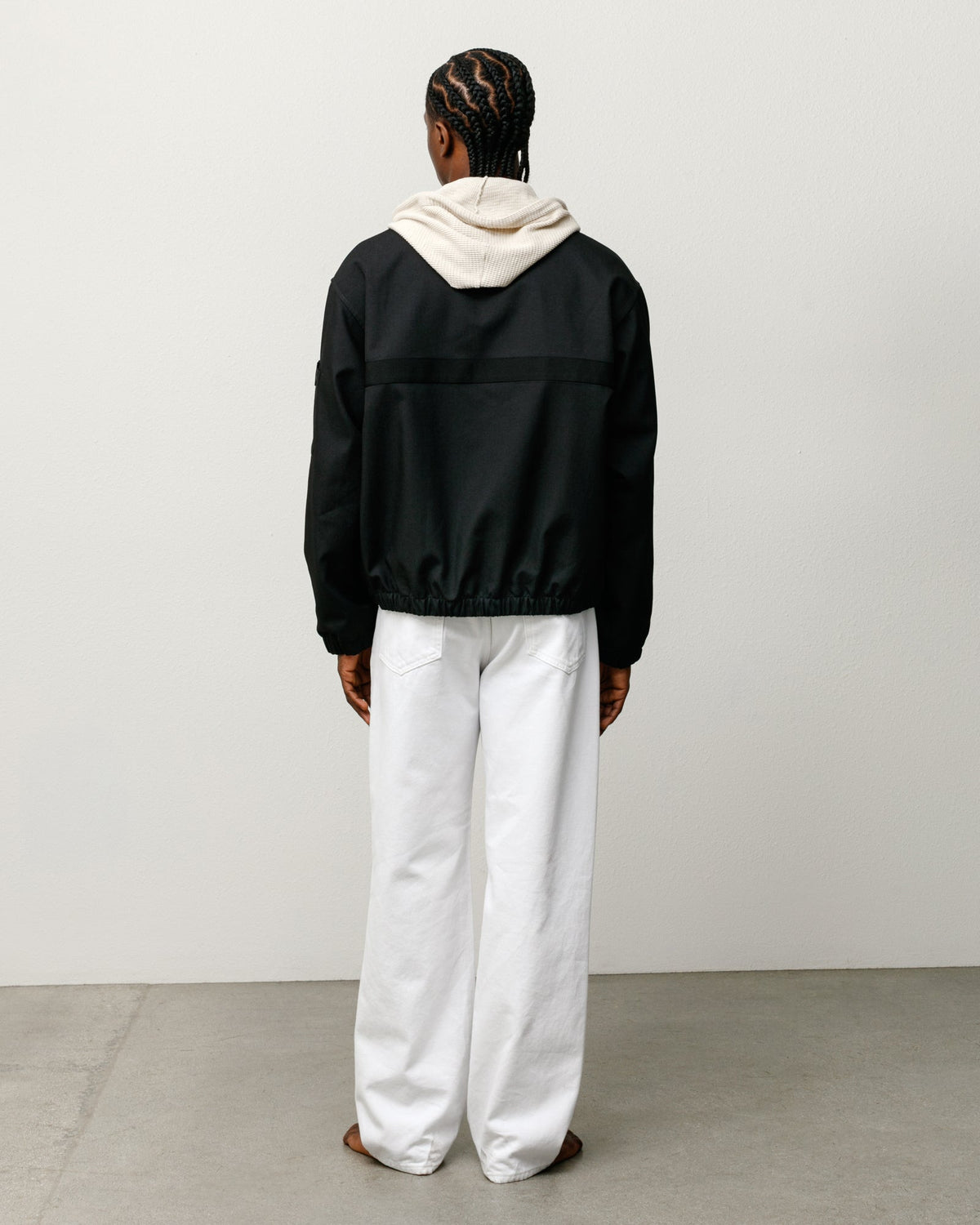 Mechanic Jacket in Black, back view with elastic hem and boxy fit, styled over a hoodie