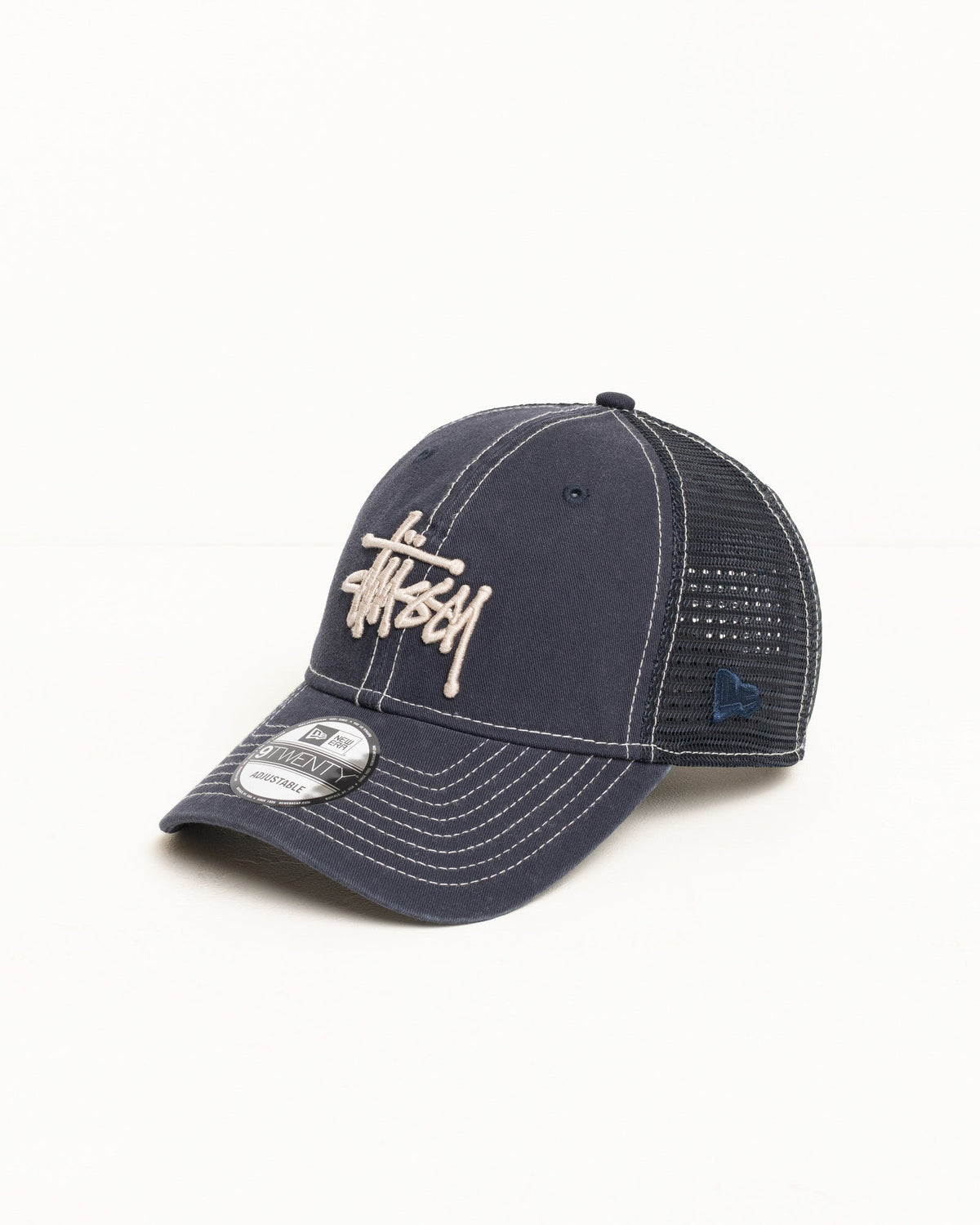 9TWENTY Washed Basic Trucker cap in navy with mesh back and Stüssy logo