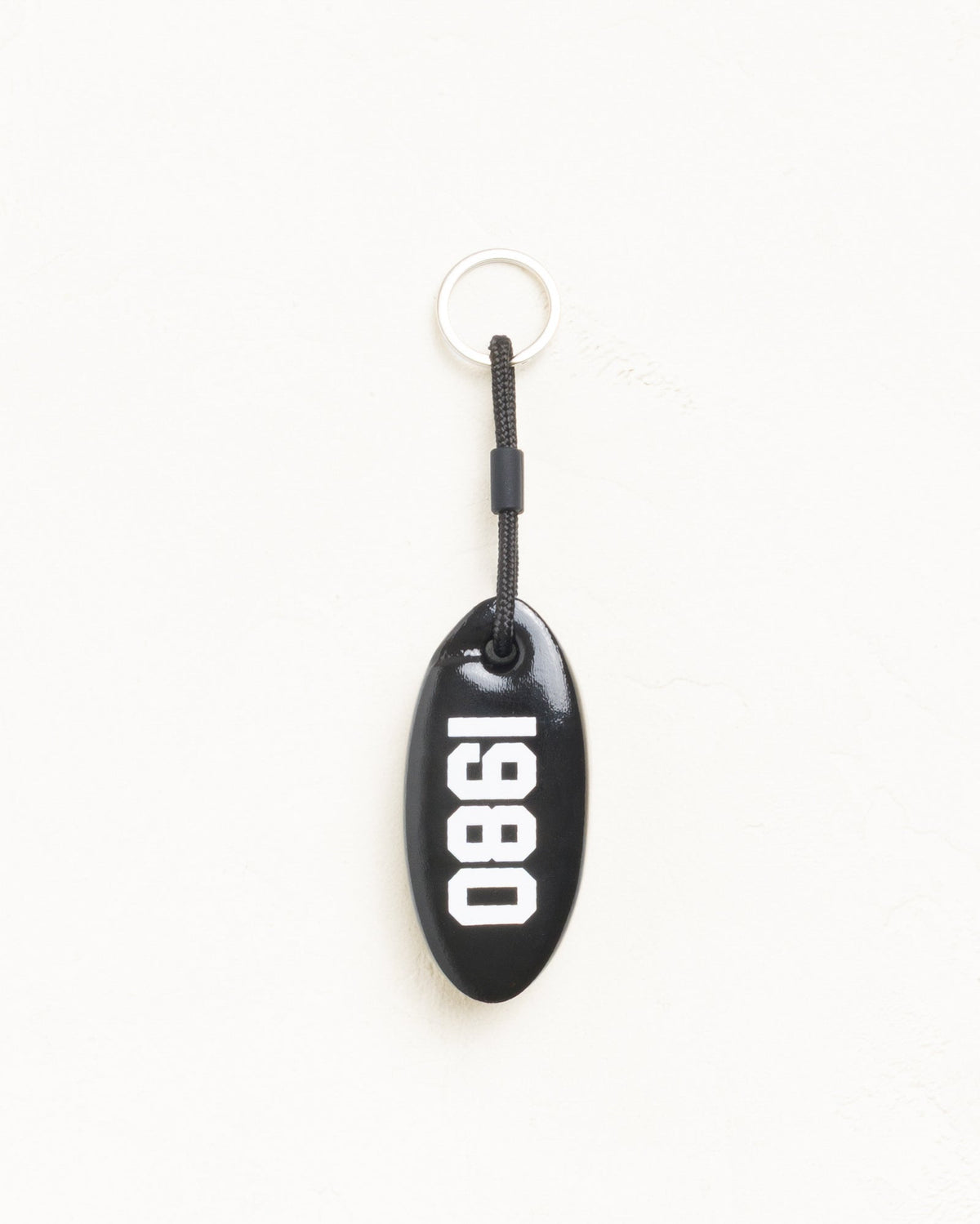 Floatie Keychain accessory in black vinyl-coated foam with 1980 print